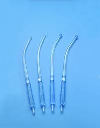 Four clear plastic medical suction tips laid side by side on a blue background.